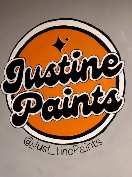 The Justine Paints logo hand-painted on the studio wall